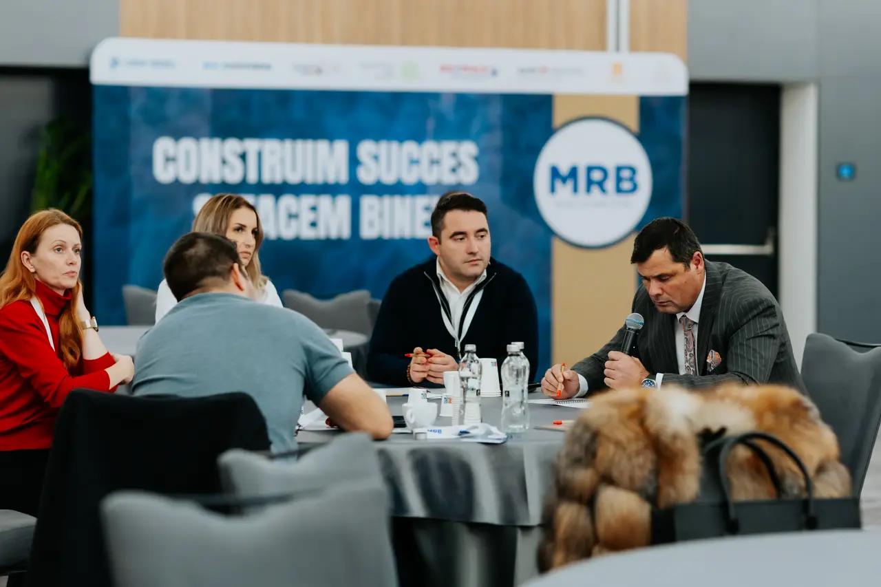 Participanți la masă în fața panoului MRB, MRB 2025